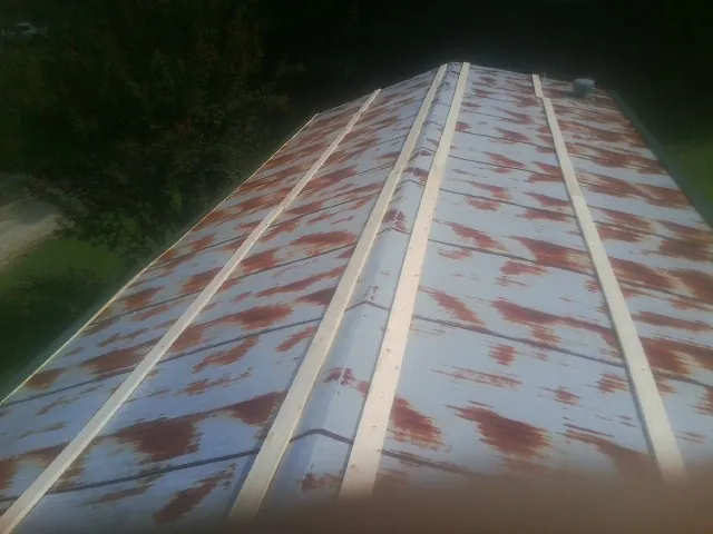 Rusted metal roof panels with new wood purlins before replacement — Storm Damage Roof Repair in Wever by Roofing Brothers
